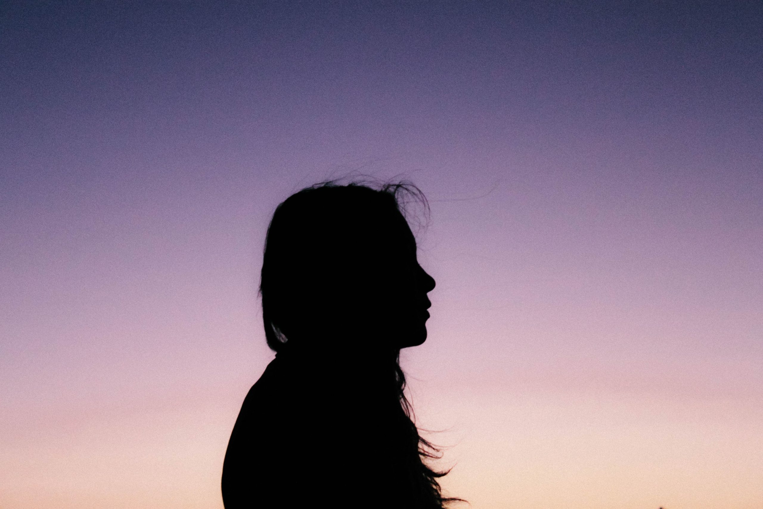 A silhouette of a woman at sunset.